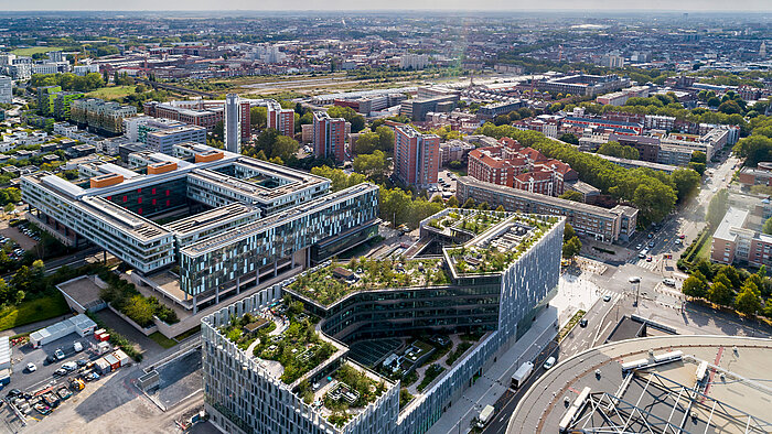 Das Gebäude ist durchgehend von grüner Vegetation umgeben. 