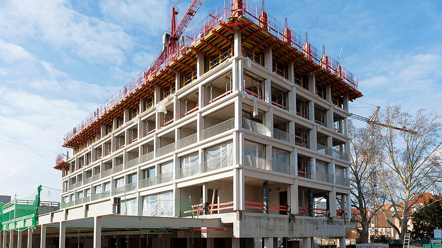 Die Gesimse aus weißen Betonfertigteilen sind mit den tragenden Wärmedämmelementen Schöck Isokorb für auskragende Bauteile befestigt und thermisch getrennt. Der Rohbau konnte so unter anderem ohne Gerüst fertiggestellt werden. 